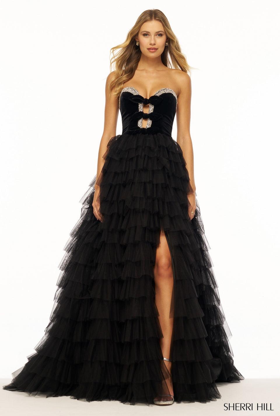 sherri hill Strapless ballgown with a ruffle skirt and slit and a velvet bodice embellished with bows rhinestone details and cut-outs